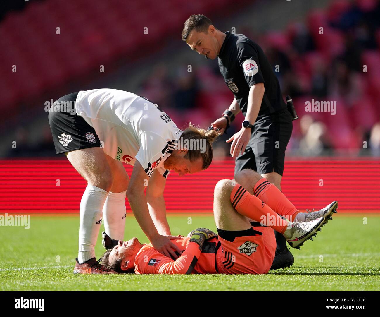 Hereford's Jamie Grimes (left) checks on the condition of team-mate Brandon Hall during the Buildbase FA Trophy 2020/21 Final at Wembley Stadium, London. Picture date: Saturday May 22, 2021. Stock Photo