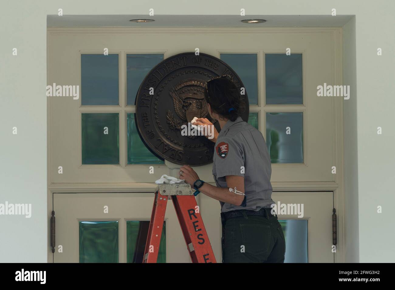 Washington, United States Of America. 22nd May, 2021. A member of the National Park Service cleans the Presidential Seal at the entrance to the West Wing of the White House in Washington, ?DC, May 22, 2021. Credit: Chris Kleponis/Pool/Sipa USA Credit: Sipa USA/Alamy Live News Stock Photo