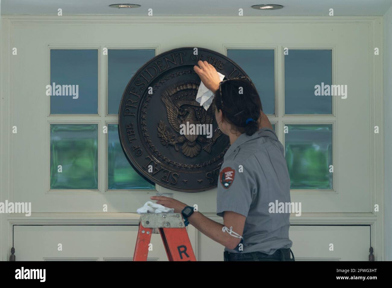 Washington, United States Of America. 22nd May, 2021. A member of the National Park Service cleans the Presidential Seal at the entrance to the West Wing of the White House in Washington, ?DC, May 22, 2021. Credit: Chris Kleponis/Pool/Sipa USA Credit: Sipa USA/Alamy Live News Stock Photo