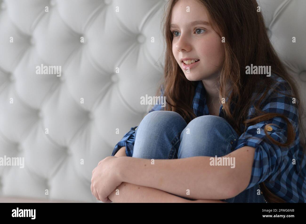 Portrait of cute girl sitting on the floor Stock Photo - Alamy