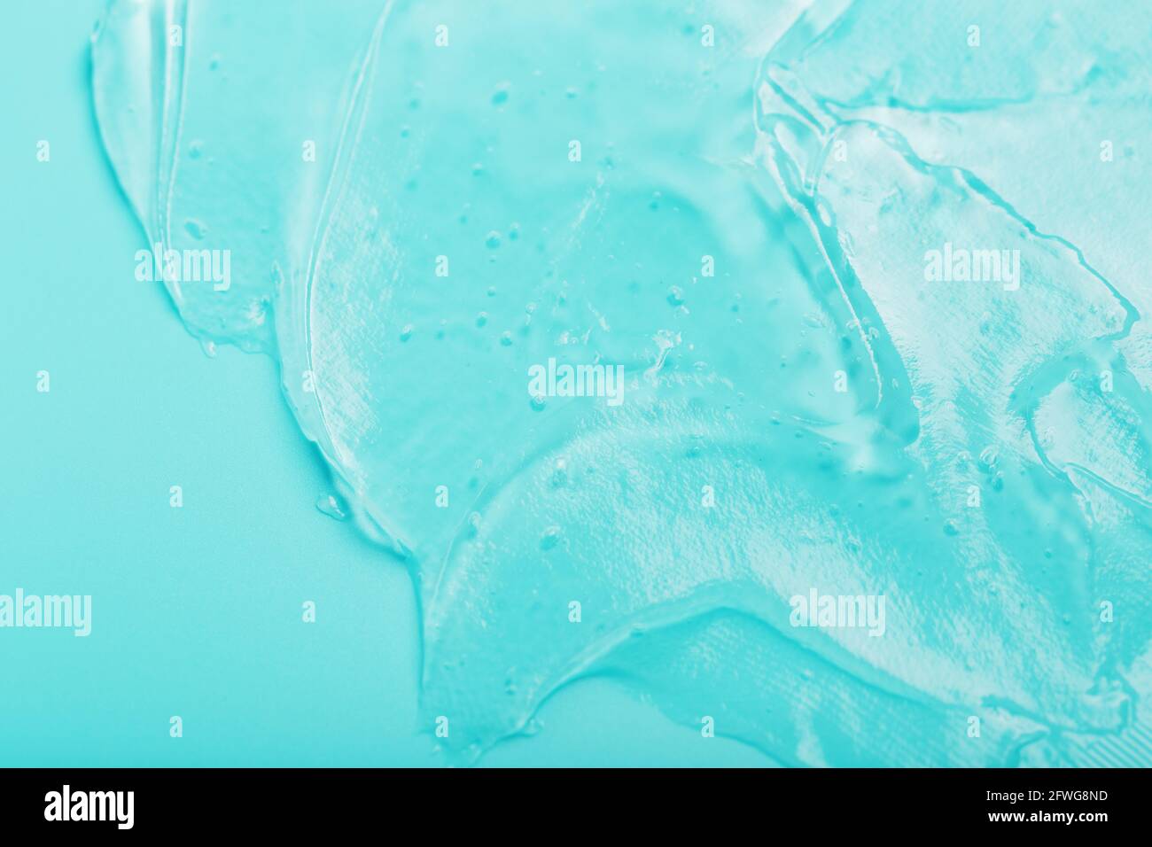 Gel with hyaluronic acid in the form of a smear of glossy texture on a cyan background. Antibacterial cosmetics Stock Photo