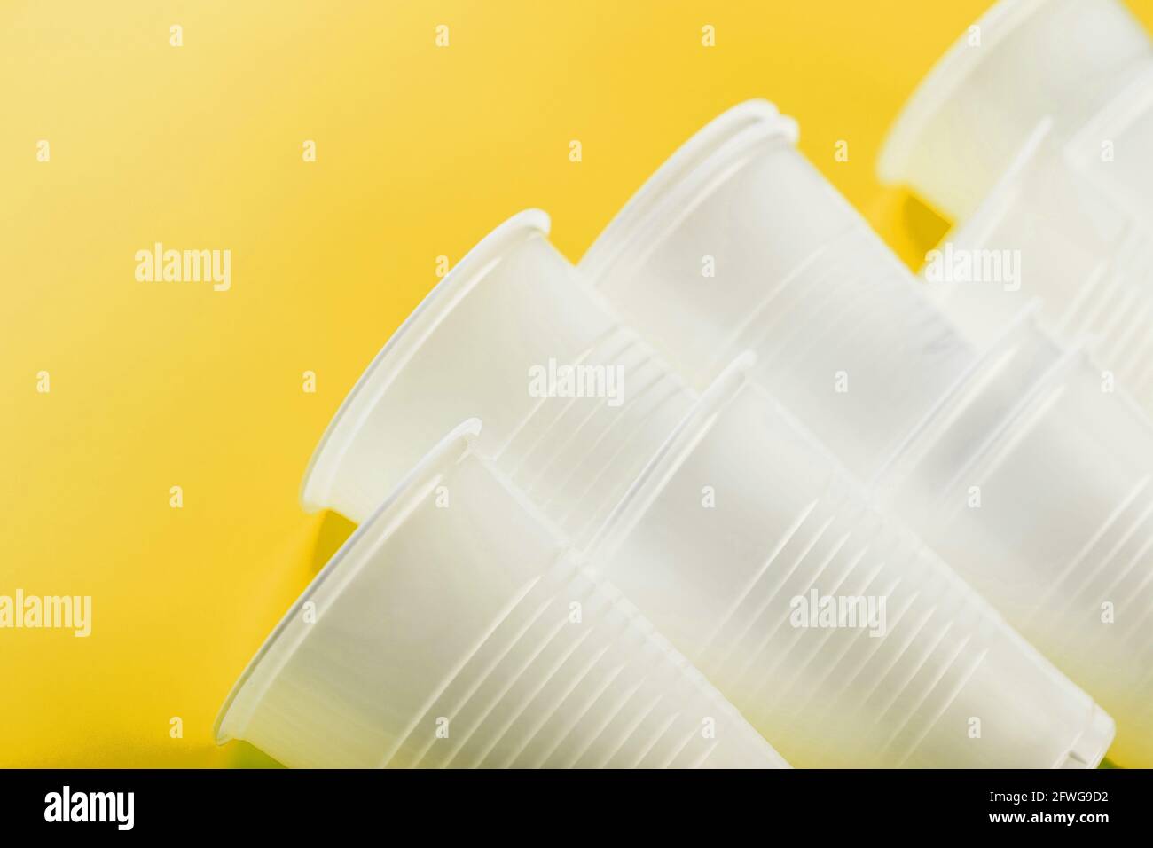 Plastic tableware on a yellow background with free space. Disposable tableware Stock Photo