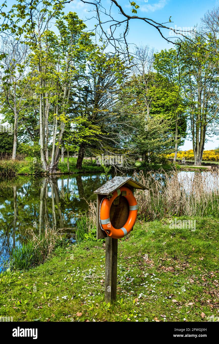 Life belt or ring beside small pond or lake in Archerfield estate, East Lothian, Scotland, UK Stock Photo