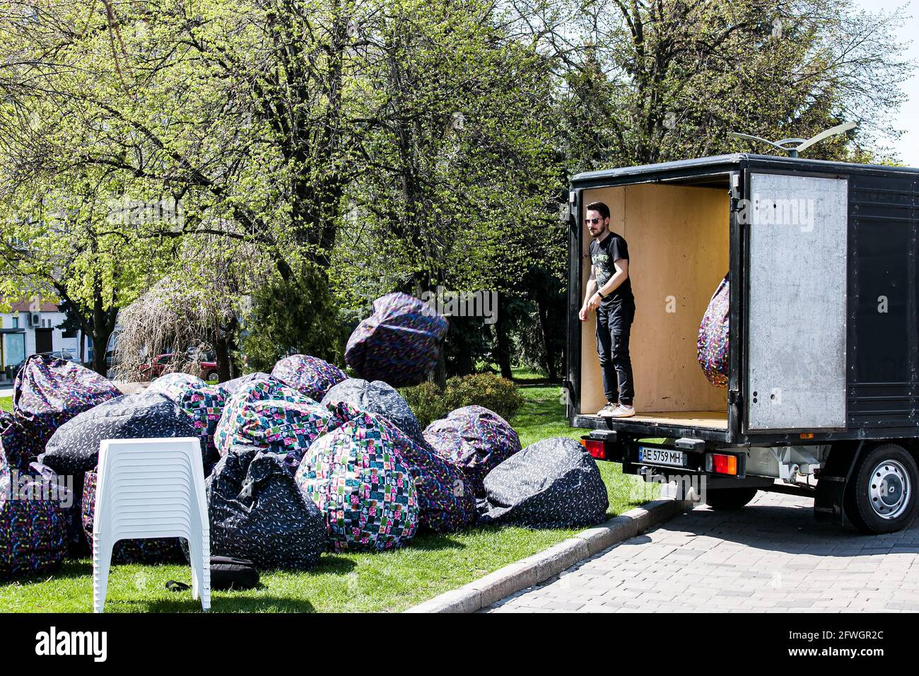 Dnepropetrovsk, Ukraine - 01.05.2021: preparing the summer cafe for the season. Unloading soft outdoor seat-chairs. Stock Photo