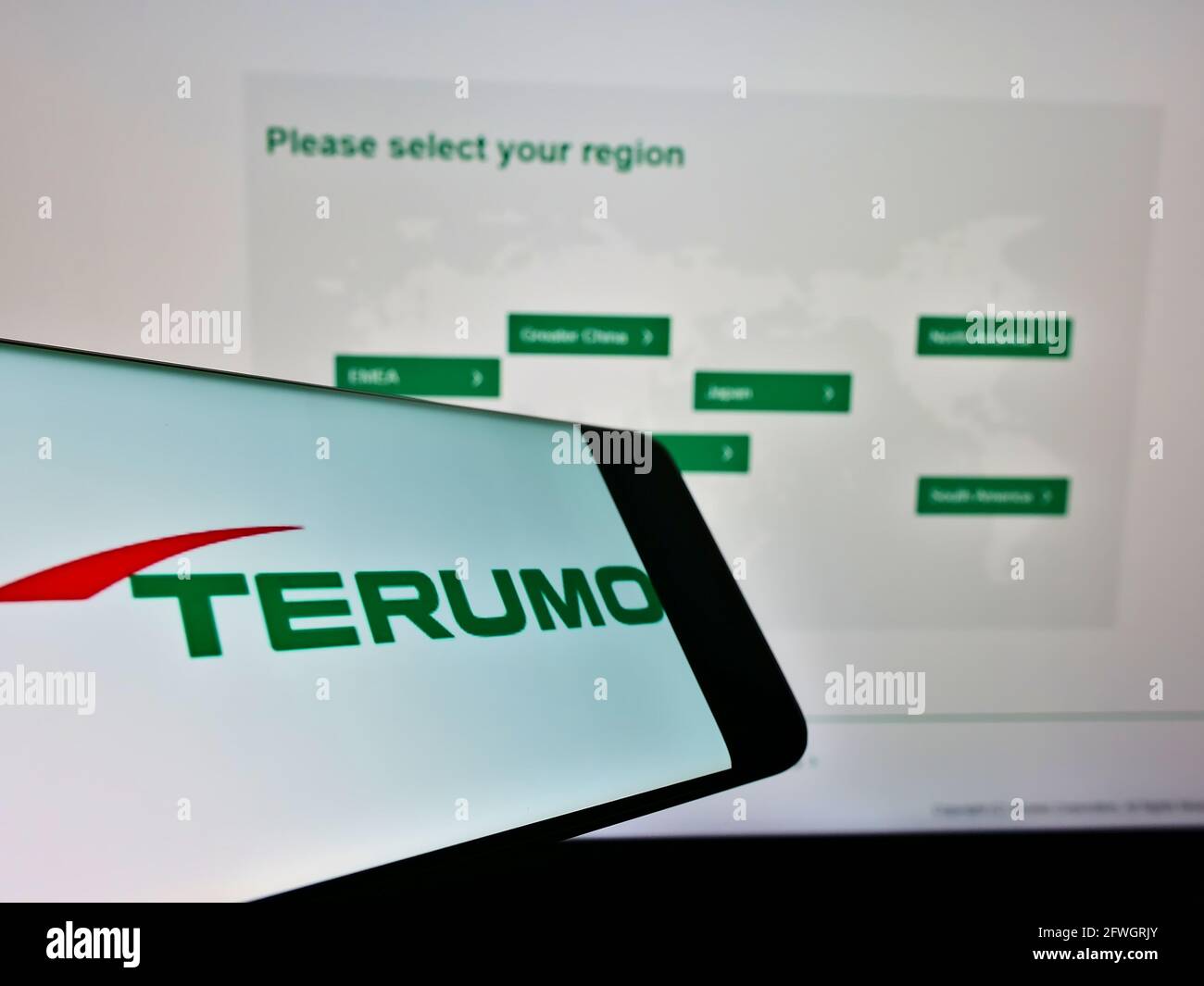 Smartphone with logo of Japanese medical equipment manufacturer Terumo Corp on screen in front of website. Focus on center-right of phone display. Stock Photo