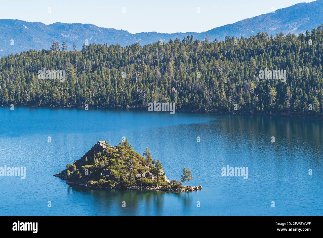 Fannette Island surrounded by blue water with reflections of trees in Emerald Bay, Lake Tahoe, California on clear sunny autumn day in close up Stock Photo