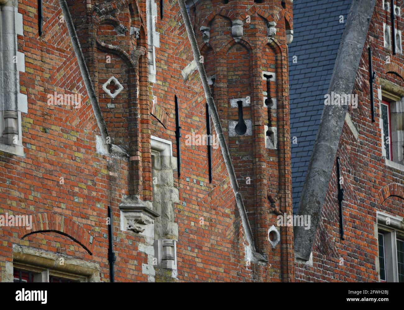 Old Gothic style buildings with a brick facade and a shingles rooftop
