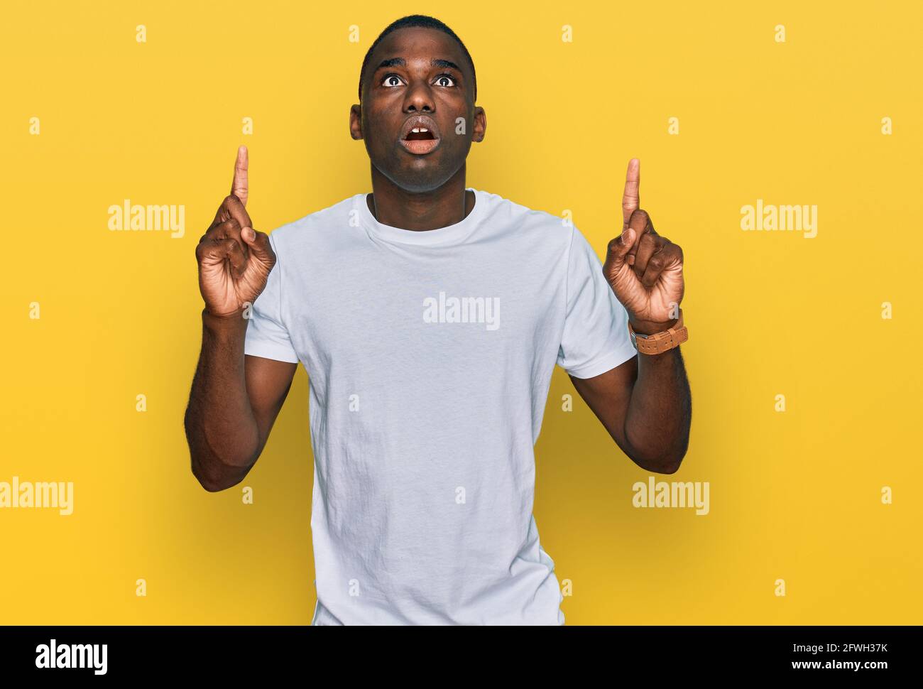 Young african american man wearing casual white t shirt amazed and ...