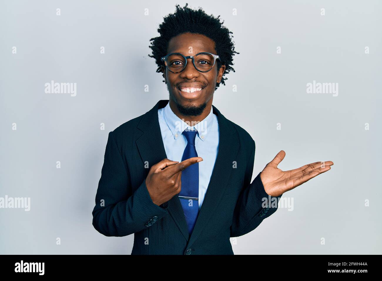 Young african american man wearing business suit amazed and smiling to ...