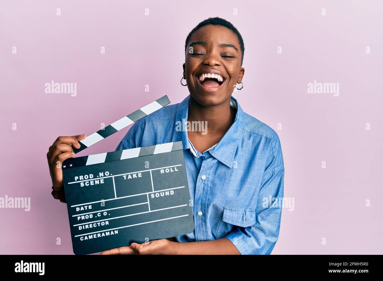 Young african american woman holding video film clapboard smiling and  laughing hard out loud because funny crazy joke Stock Photo - Alamy