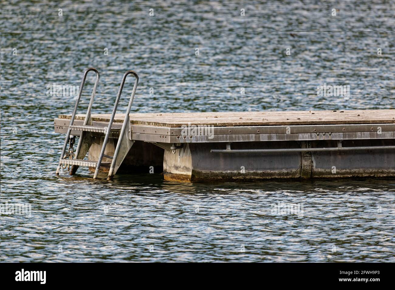 empty wooden floating platform with metal container as floating body on a lake, due to the corona virus all bathing facilities remain closed until fur Stock Photo