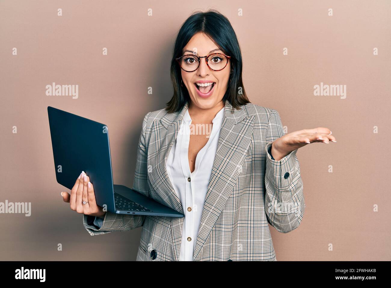 Young hispanic woman working using computer laptop celebrating ...