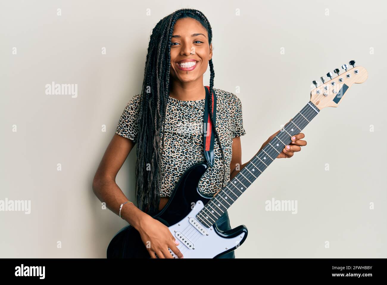 African american woman playing electric guitar smiling with a happy and  cool smile on face. showing teeth Stock Photo - Alamy