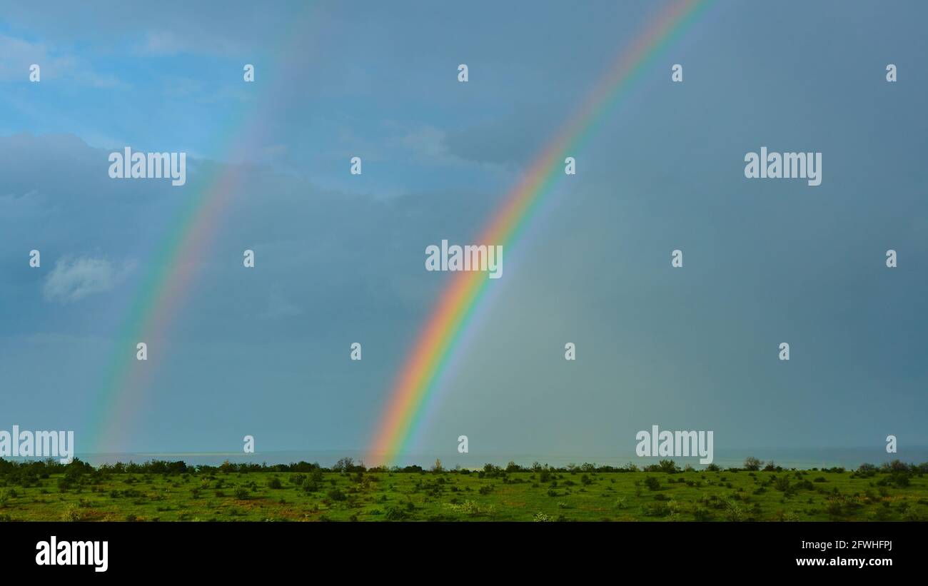 The Rainbow over a field after thunderstorm Stock Photo - Alamy