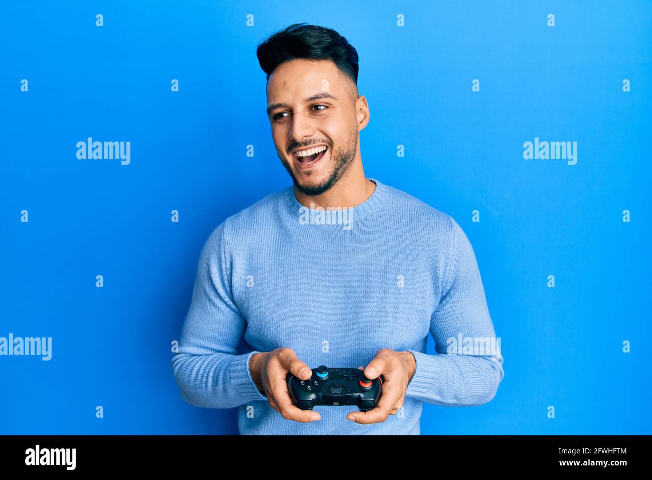 Young arab man playing video game holding controller smiling and laughing hard out loud because funny crazy joke Stock Photo - Alamy Young arab man playing video game holding controller smiling and laughing hard out loud because funny crazy joke Stock Photo - Alamy