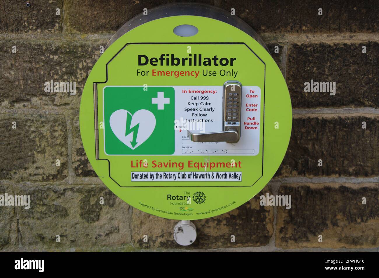 Public Defibrillator machine fastened to a brick wall Stock Photo