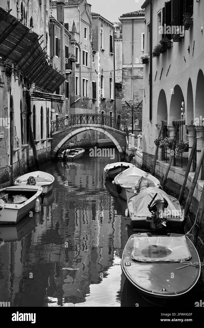 Canal in Venice with moored boats, Italy. Black and white photography ...