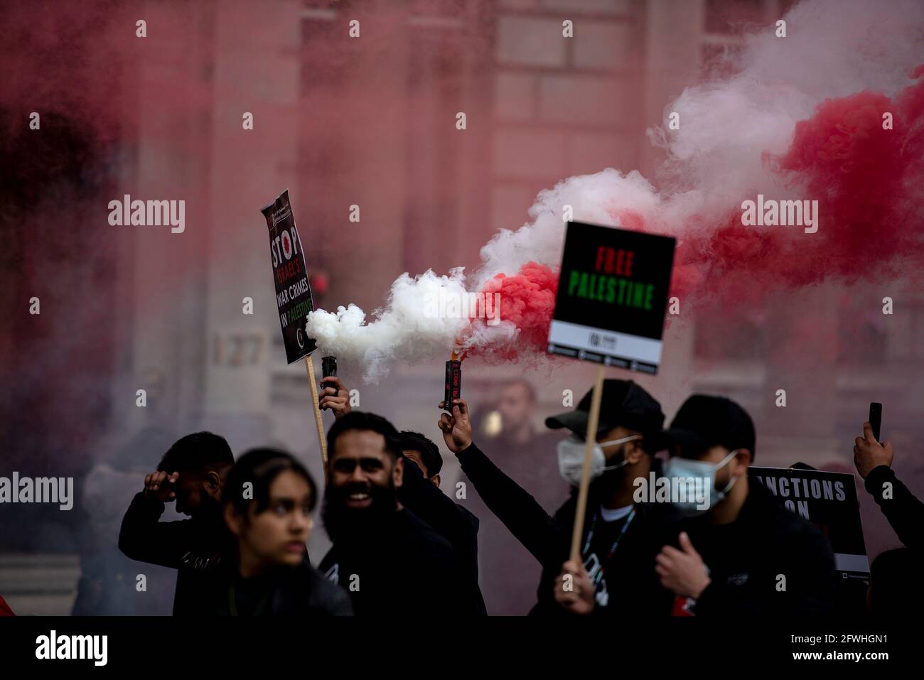 Protesters hold burning flares and placards during the demonstration.Palestinian Citizens are being subject to violent armed mobs, attempting to drive them from their homes. The violence is part of Israel's regime of institutionalised racist discrimination against the Palestinian people, amounting to the crime of apartheid. The UK Government is expected to take action, which includes implementing sanctions, military embargo to cut the supply of deadly weapons to Israel, and banning the import of goods from Israel's illegal settlements. Stock Photo