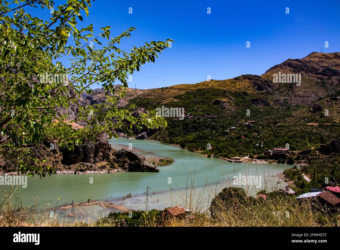 A panoramic photo of a scenery that reflects the beauty of Erzincan. The blue lake in the midst of the mountains under the sky creates a magnificent a Stock Photo