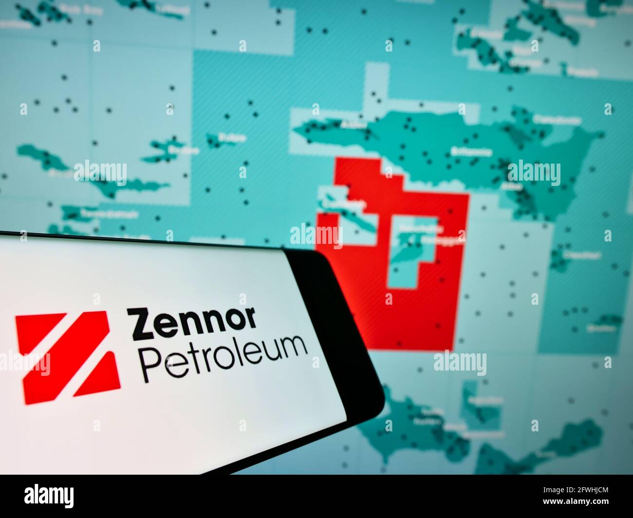 Mobile phone with logo of British oil and gas company Zennor Petroleum Ltd. on screen in front of website. Focus on center-right of phone display. Stock Photo