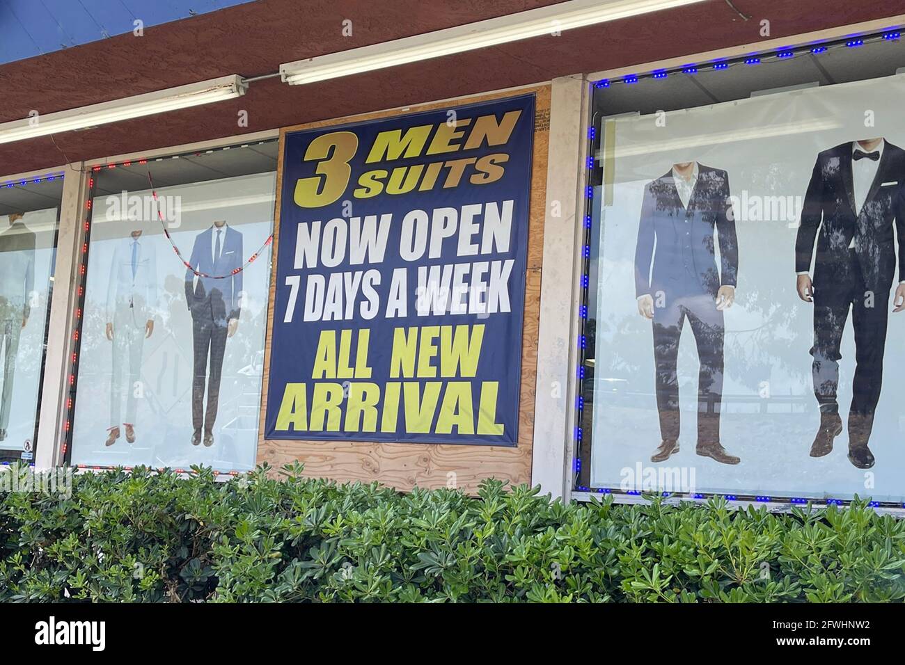 A 'Now Open 7 Days A Week' sign at 3 Men's Suits, Saturday, May 22, 2021, in Montebello, Calif. Stock Photo