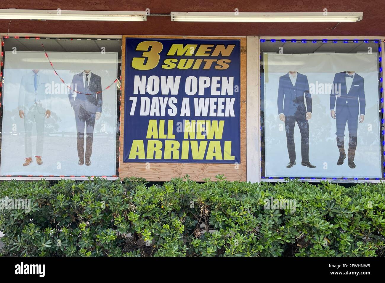 A 'Now Open 7 Days A Week' sign at 3 Men's Suits, Saturday, May 22, 2021, in Montebello, Calif. Stock Photo