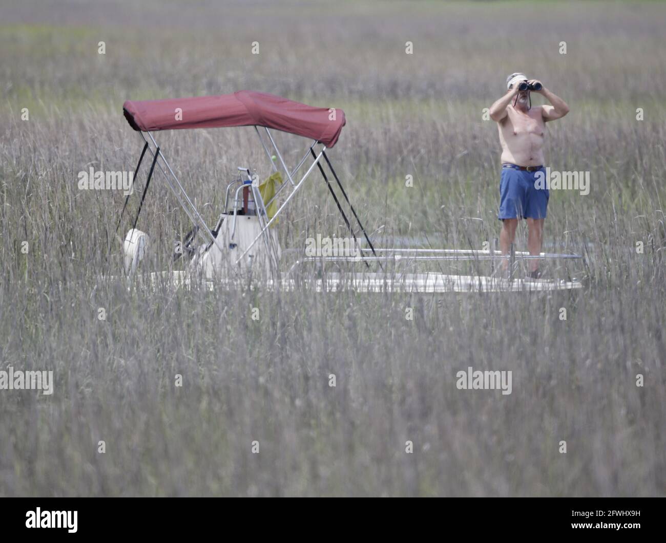 Kiawah Island, United States. 22nd May, 2021. A spectator watches Phil Mickelson's group from a boat floating in the marsh among the spartina grass in the third round of the 103rd PGA Championship at Kiawah Island Golf Resort Ocean Course on Kiawah Island, South Carolina on Saturday, May 22, 2021. Photo by John Angelillo/UPI Credit: UPI/Alamy Live News Stock Photo
