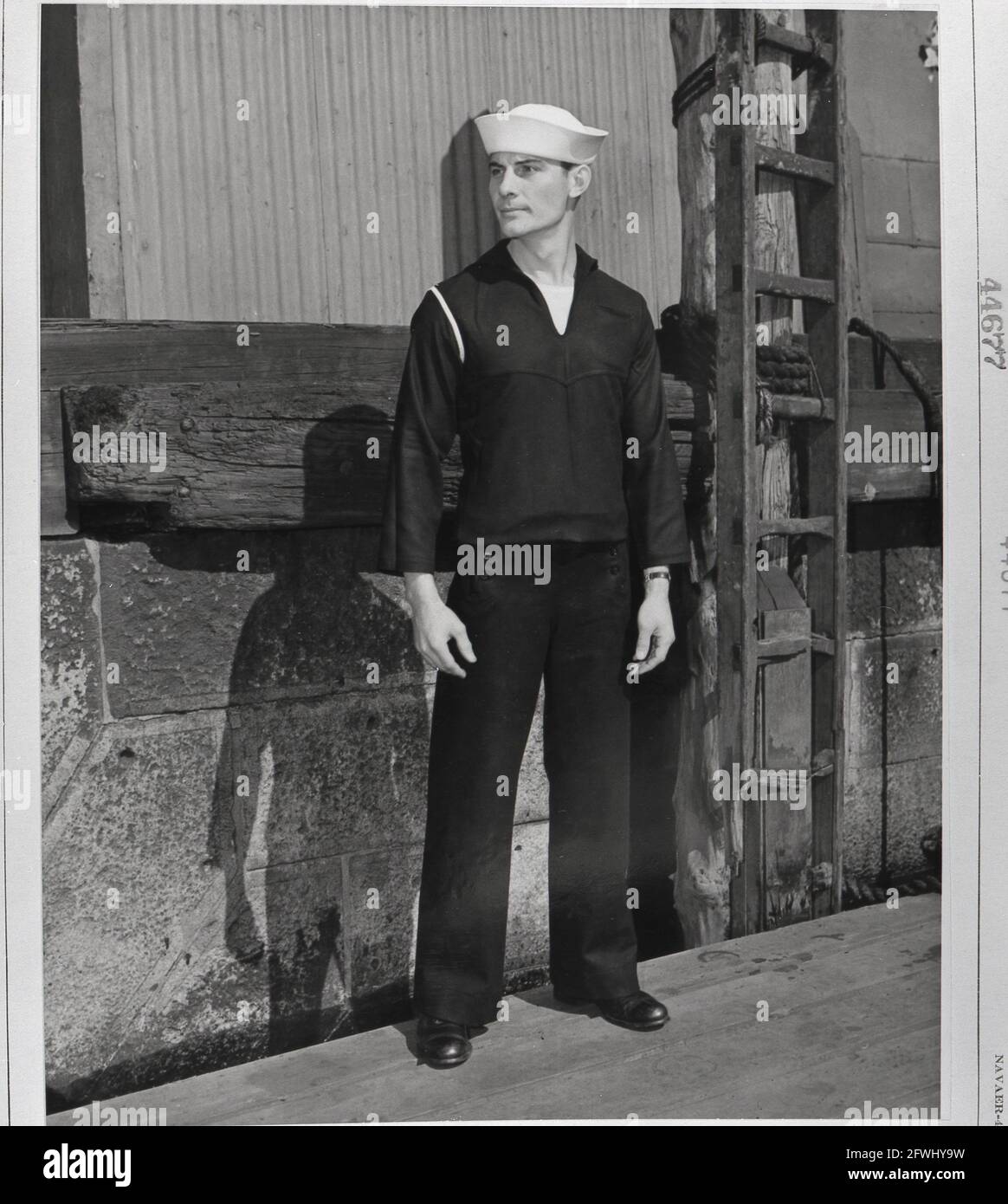 USA World War Two WWII 1940s U.S. Navy sailor uniform fashion Sailor poses on a dock to show his working clothes Stock Photo