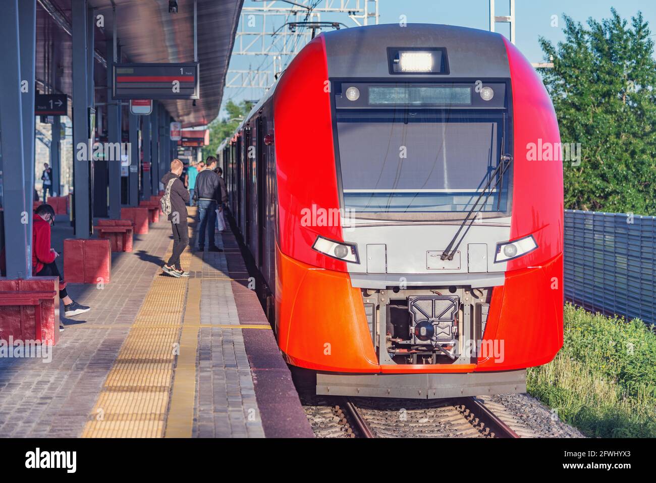 Passenger train stands by the station platform. Stock Photo