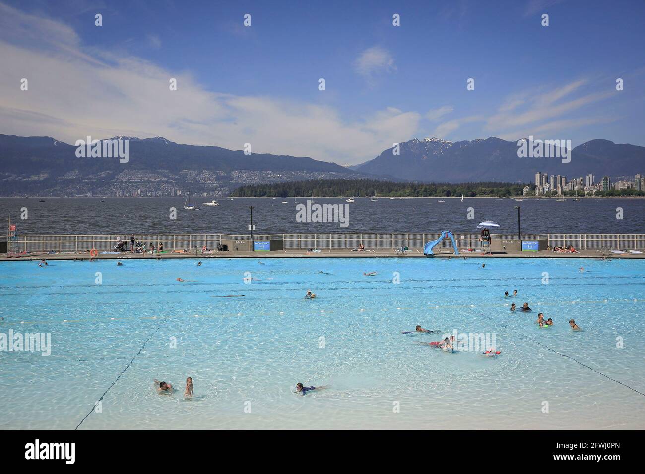 Vancouver, Canada. 22nd May, 2021. People go swimming on the first day of re-opening at the Kitsilano outdoor pool in Vancouver, British Columbia, Canada, May 22, 2021. Three of Vancouver's outdoor pools reopened Saturday. Due to the COVID-19 registration in place, anyone who wants to take a dip will have to register in advance due to pandemic-related restrictions on capacity. Credit: Liang Sen/Xinhua/Alamy Live News Stock Photo