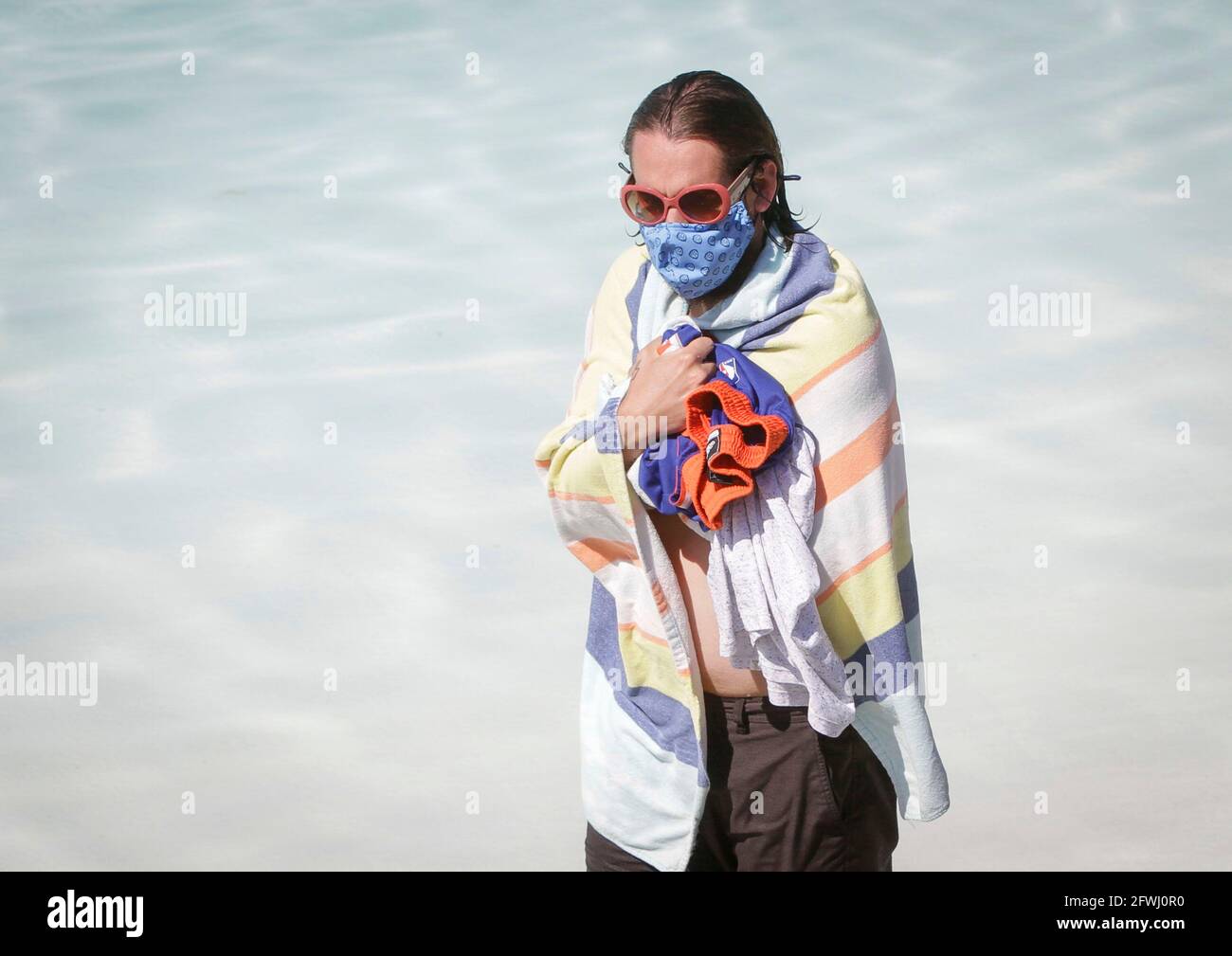 Vancouver, Canada. 22nd May, 2021. A swimmer is seen wearing a face mask on the first day of re-opening at the Kitsilano outdoor pool in Vancouver, British Columbia, Canada, May 22, 2021. Three of Vancouver's outdoor pools reopened Saturday. Due to the COVID-19 registration in place, anyone who wants to take a dip will have to register in advance due to pandemic-related restrictions on capacity. Credit: Liang Sen/Xinhua/Alamy Live News Stock Photo