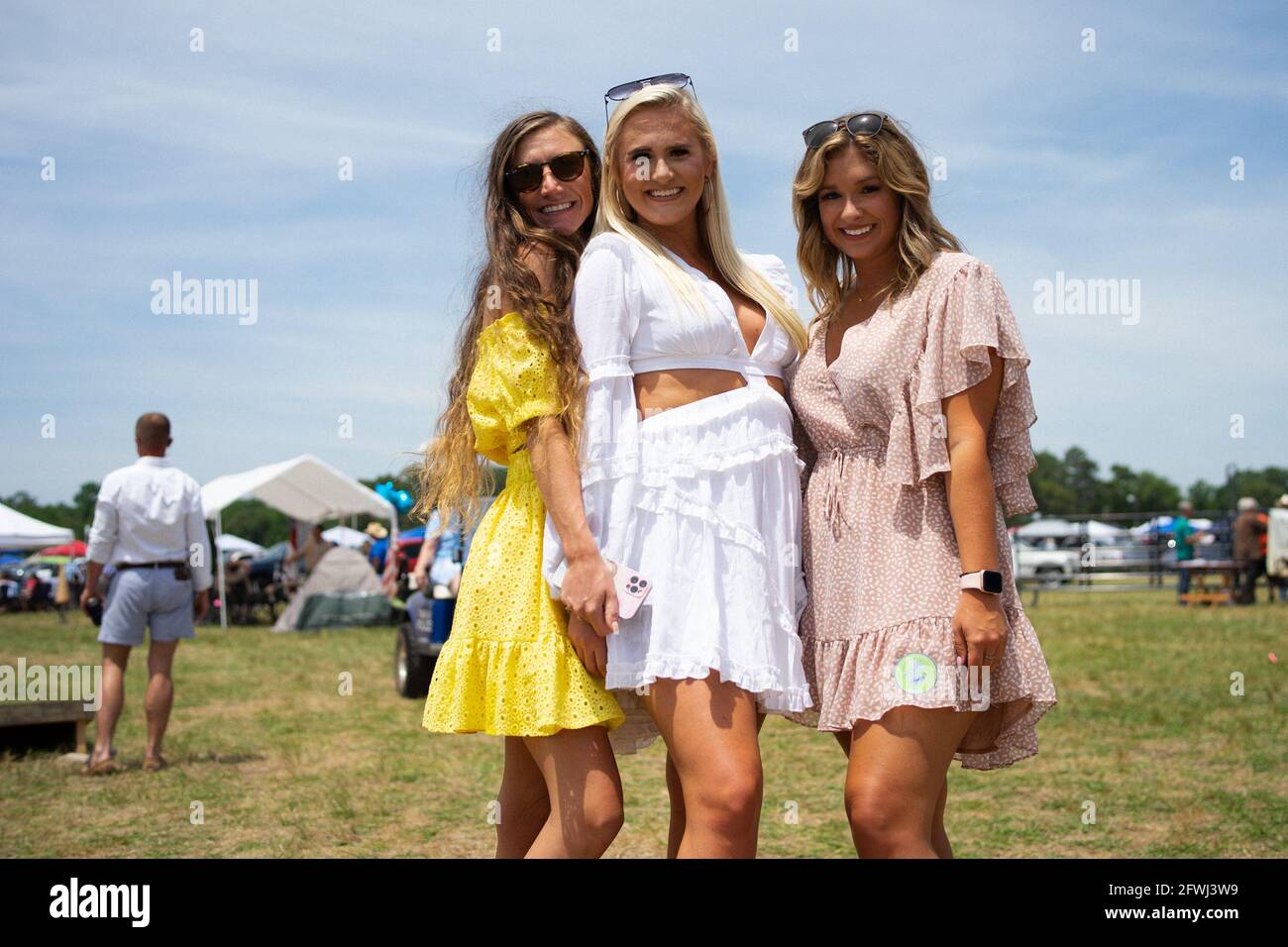 From left to right: Mackenzie Ray, Jordan Baird and Tia Bowers pose for a photo the infield of the Carolina Cup.Jockeys and horses complete the last leg of the fourth race