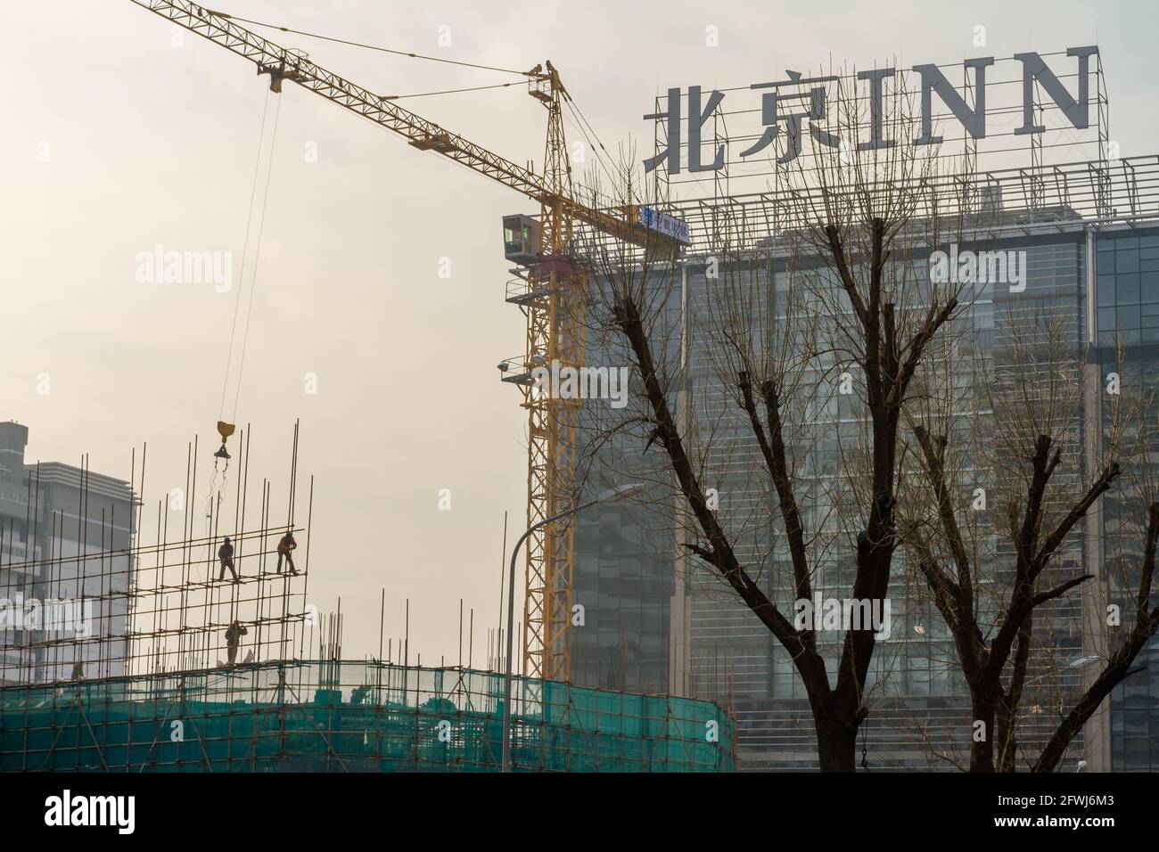 Beijing, China - January 17, 2015: Construction workers working on scaffolding at a construction site in Beijing Stock Photo