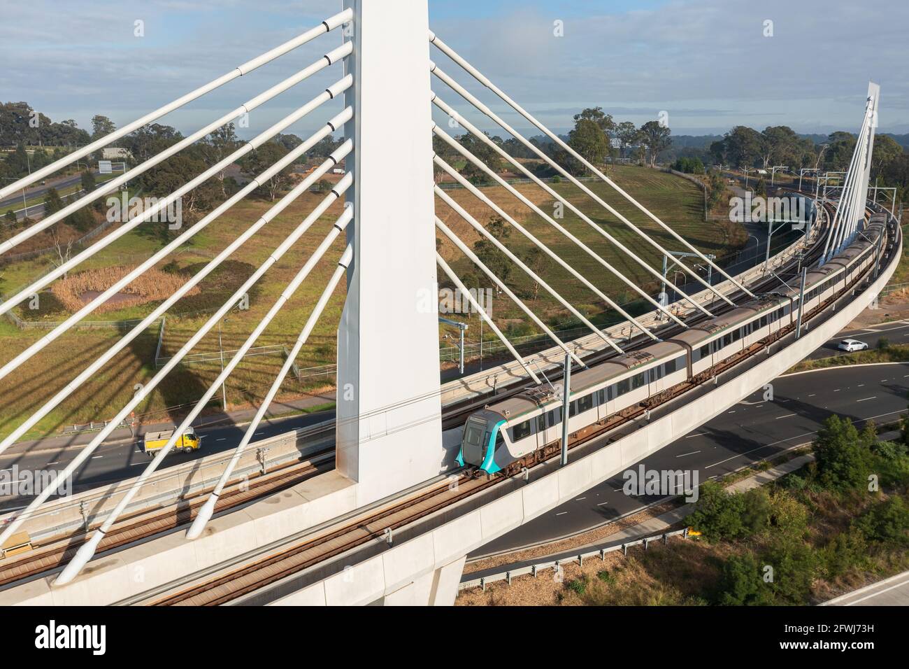 A Sydney Metro train traversing a bridge over Windsor Rd, Rouse Hill, NSW, Australia. Stock Photo