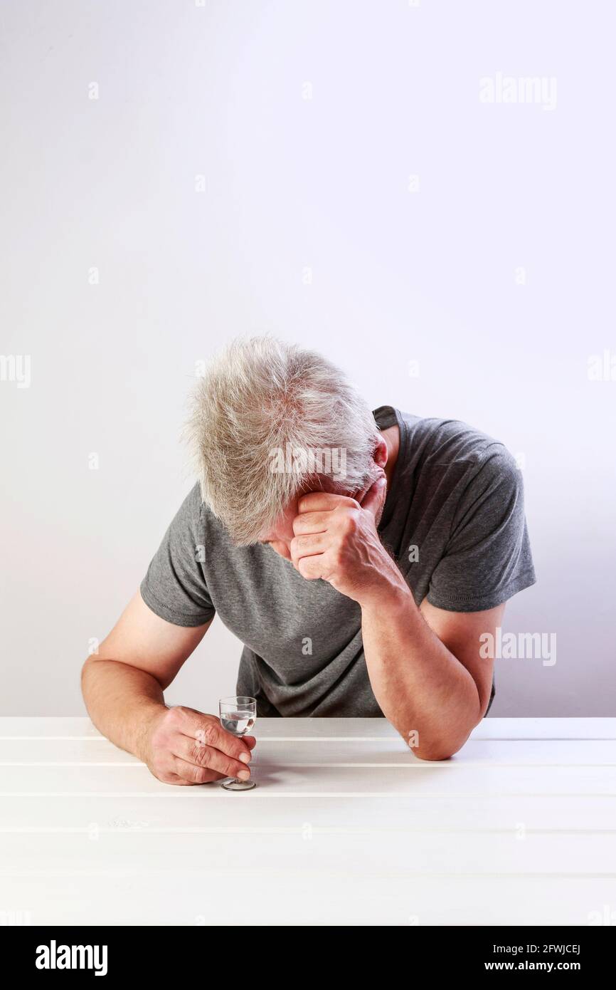 Lonely man drinking vodka. Idea of alcoholism Stock Photo