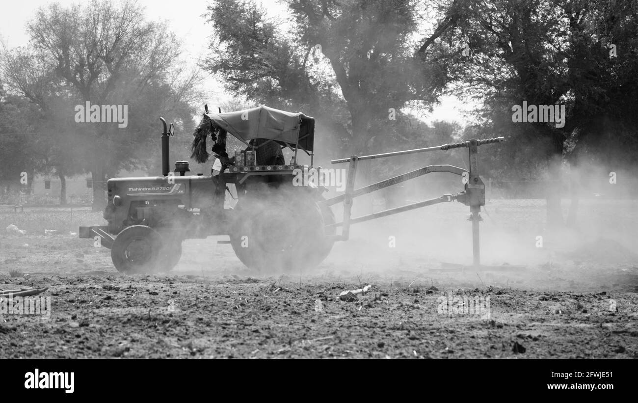 07 May 2021- Reengus, Sikar, India. Black and white shot of agriculture concept. Farmer operating fertilizer spreader machine with tractor. Stock Photo