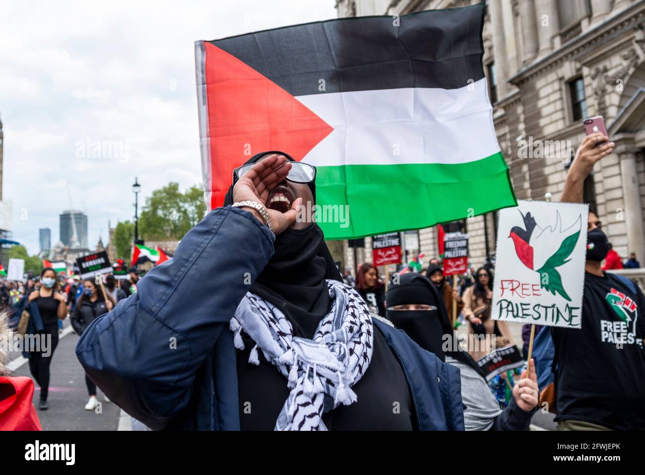 Protester at National Demonstration for Palestine, Free Palestine, in London, UK. Female chanting, with flag. Free Palestine placard Stock Photo