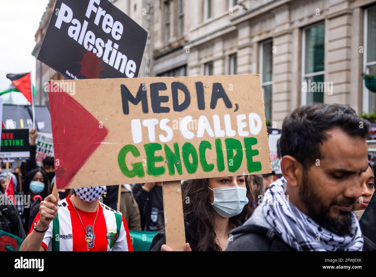 Protester at National Demonstration for Palestine, Free Palestine, in London, UK. Placard stating, media, it's called genocide. Lack of media coverage Stock Photo