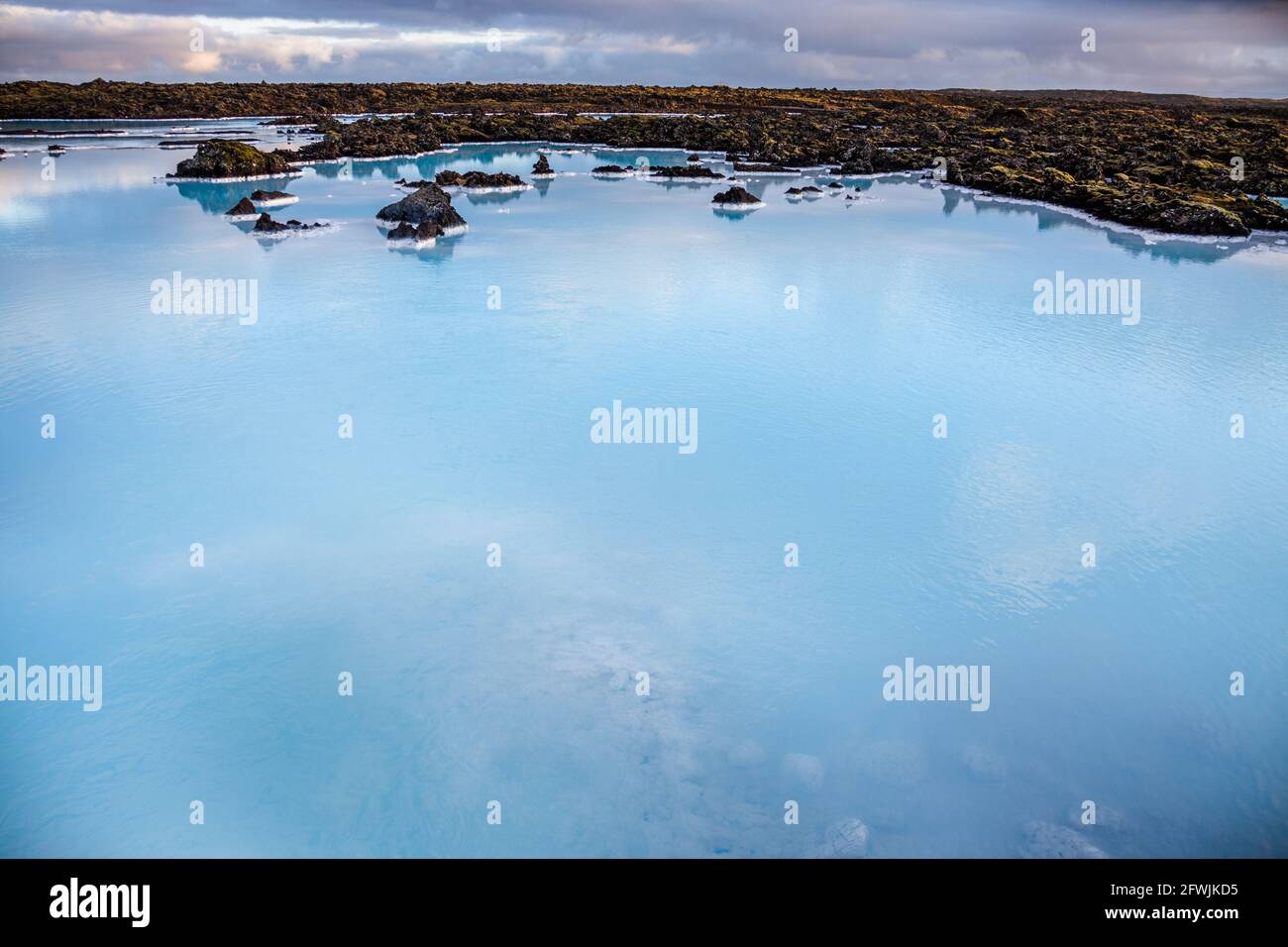 The rich geothermally warmed sea waters and volcanic lava terrain surrounding the Blue Lagoon Resort and Spa at dawn in Iceland Stock Photo