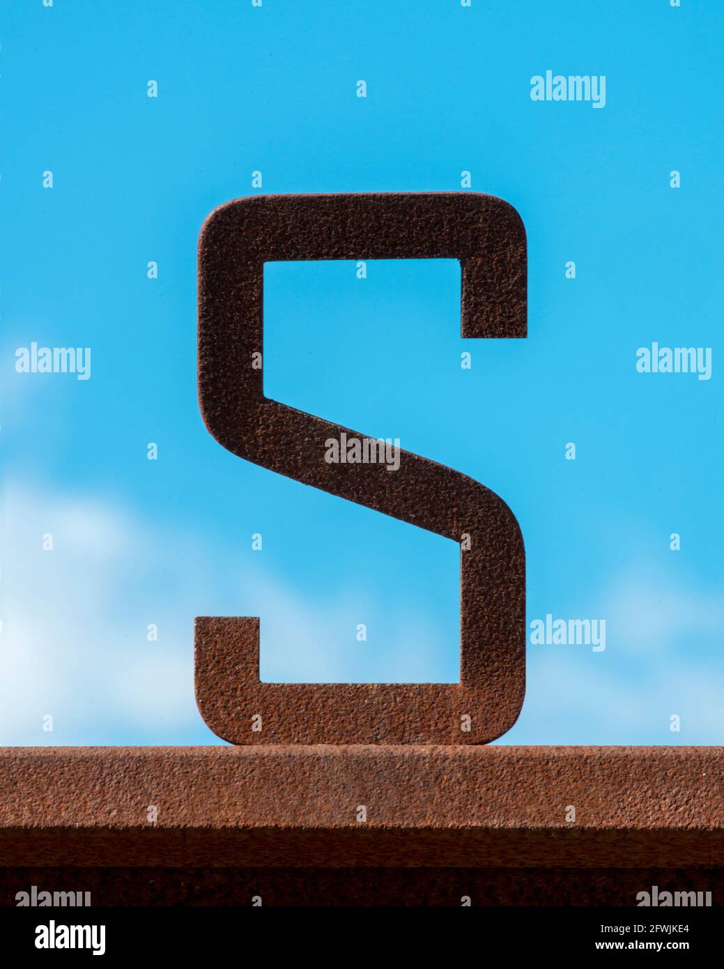 Rusty letter S against a blue sky Stock Photo
