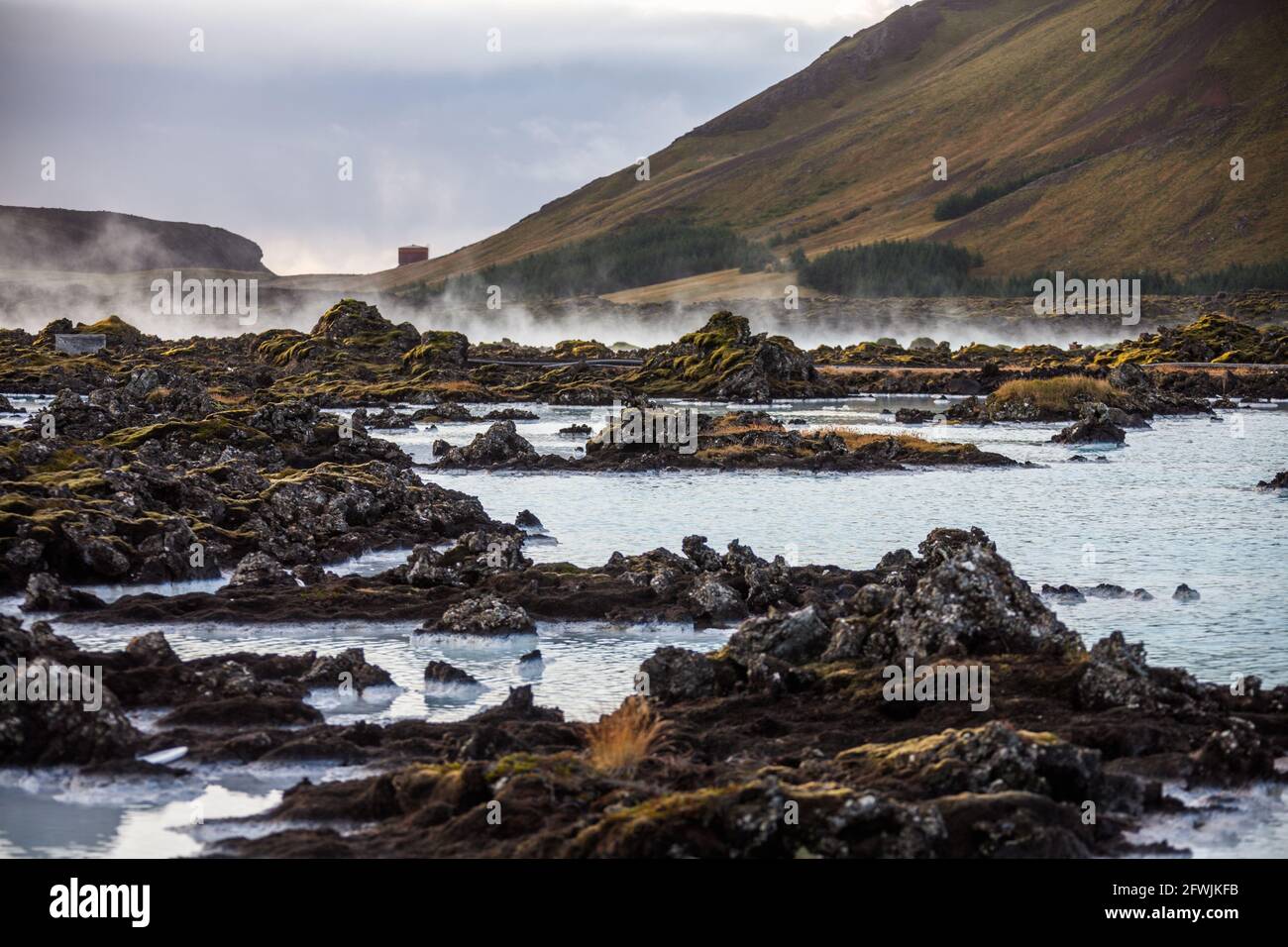 The rich geothermally warmed sea waters and volcanic lava terrain surrounding the Blue Lagoon Resort and Spa at dawn in Iceland Stock Photo