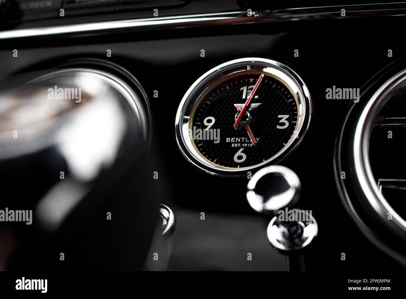 The Bentley Clock Set Into The Gloss Black Centre Console Of A 2019 Bentley Continental GTC Convertible Stock Photo