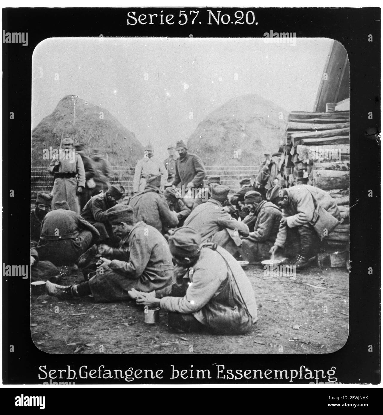 Projection für Alle - Die Eroberung Serbiens. Serie 57. No 20. Serbische Gefangene beim Essenempfang. Der Krieg der Mittelmächte gegen Serbien erreichte seinen Höhepunkt im Herbst 1915 und endete mit der Besetzung ganz Serbiens im Dezember 1915. Die Firma „Projection für Alle“ wurde 1905 von Max Skladanowsky (1861-1939) gegründet. Sie produzierte bis 1928 fast 100 Serien zu je 24 Glasdias im Format 8,3 x 8,3 cm im sog. Bromsilber-Gelatine-Trockenplatten Verfahren. Die Serien umfassten Städte, Länder, Landschaften, Märchen und Sagen, das Alte Testament u. den 1. Weltkrieg. Stock Photo