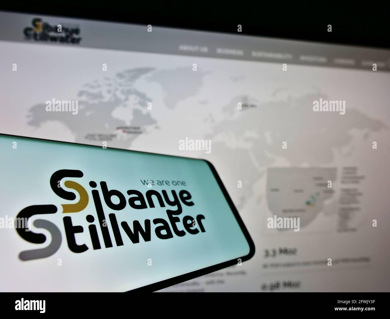 Cellphone with logo of South African mining company Sibanye Stillwater Limited on screen in front of web page. Focus on center of phone display. Stock Photo