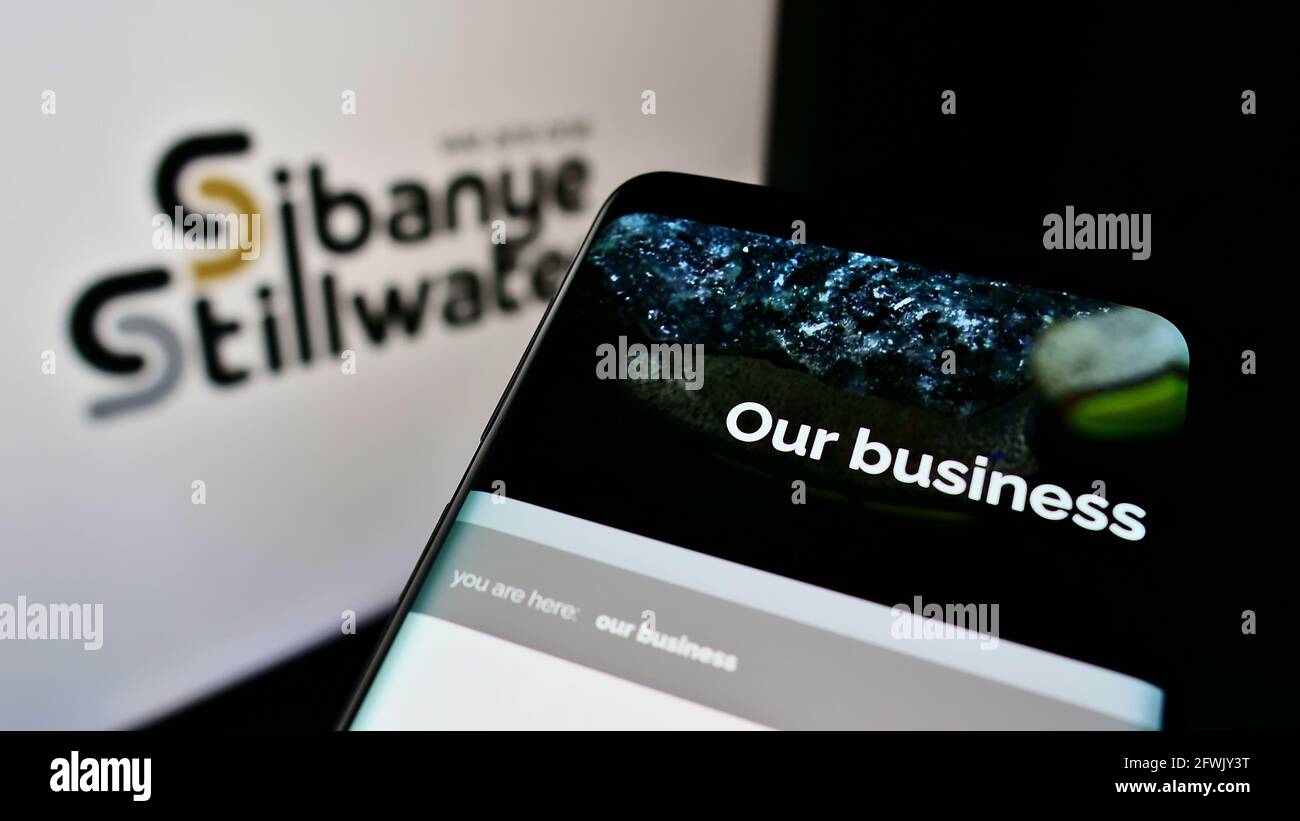 Mobile phone with webpage of South African mining company Sibanye Stillwater Limited on screen in front of logo. Focus on top-left of phone display. Stock Photo
