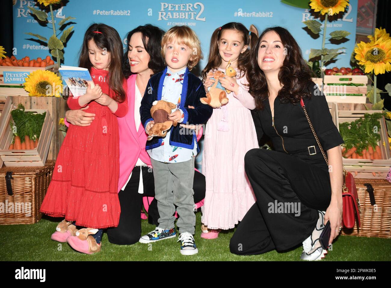 Sally Wood (second from left) with daughters Gracie Jane and Alice Rose, and Melanie Hamrick (right) with son Deveraux, arriving for the gala screening of Peter Rabbit 2 at the Picturehouse Central Cinema, in central London. Picture date: Sunday May 23, 2021. Stock Photo