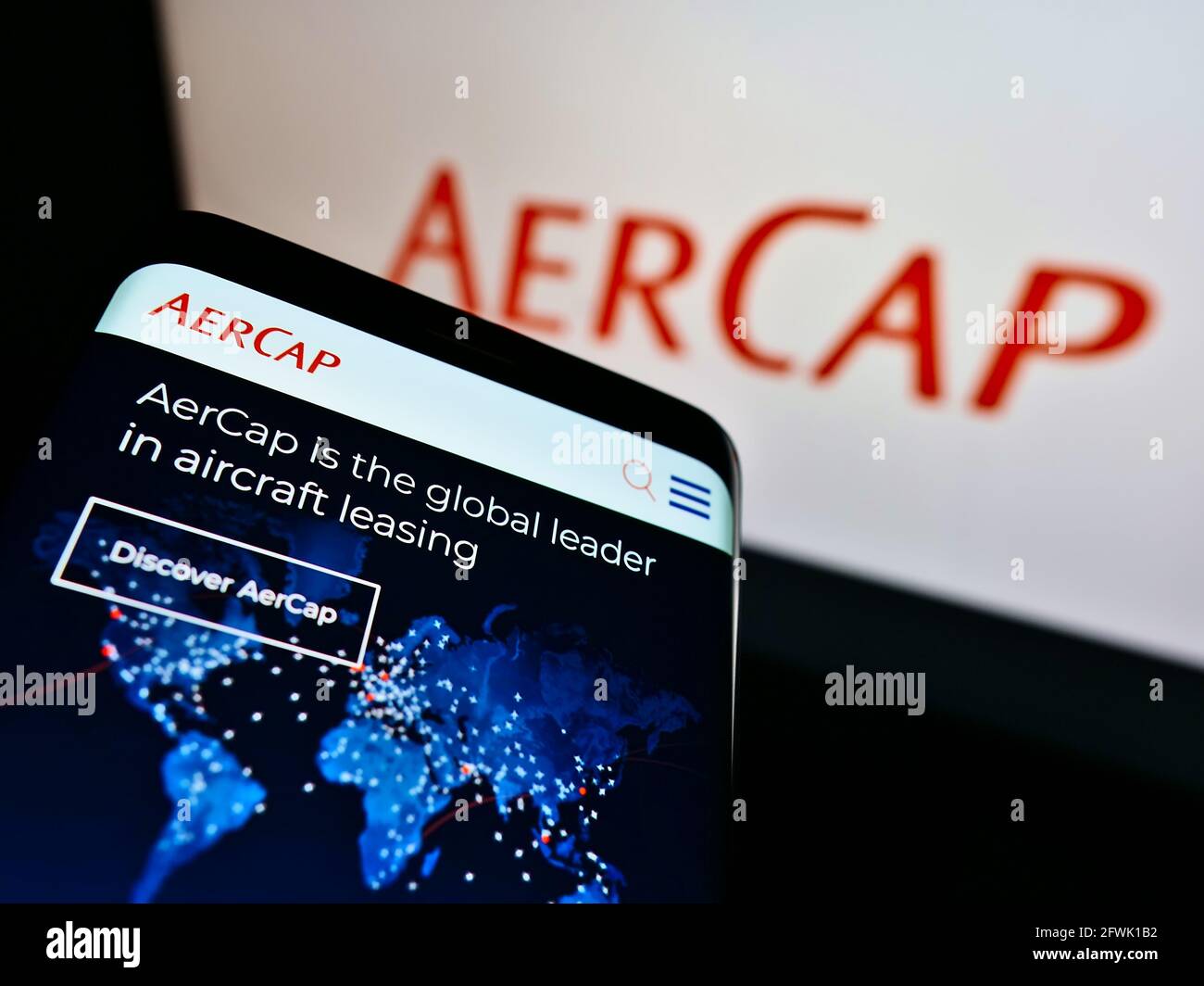 Smartphone with webpage of aircraft leasing company AerCap Holdings N.V. on screen in front of business logo. Focus on top-left of phone display. Stock Photo