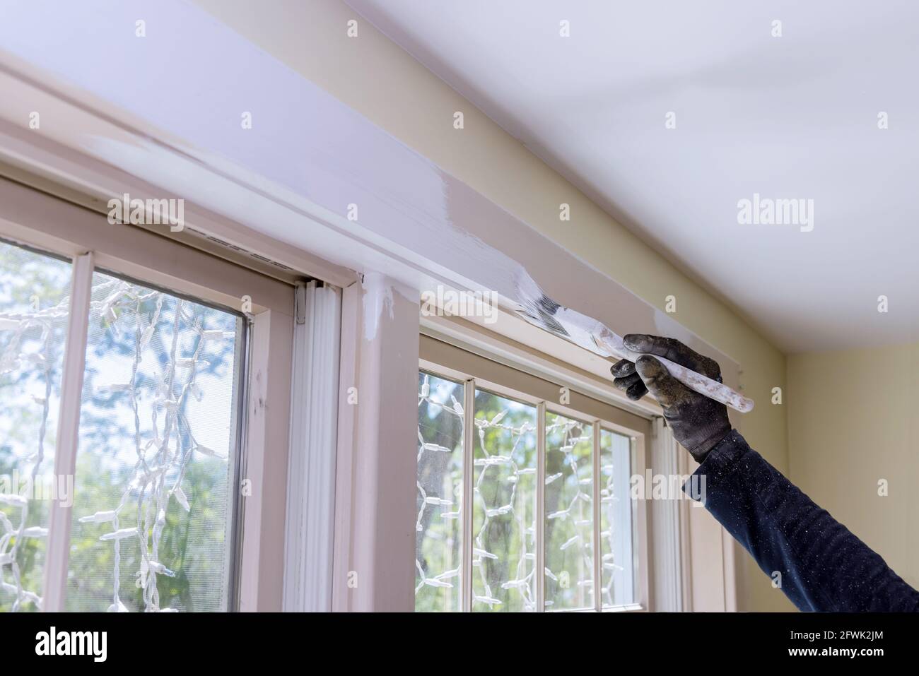 Closeup a mans hand with painting a window frame with white color Stock ...