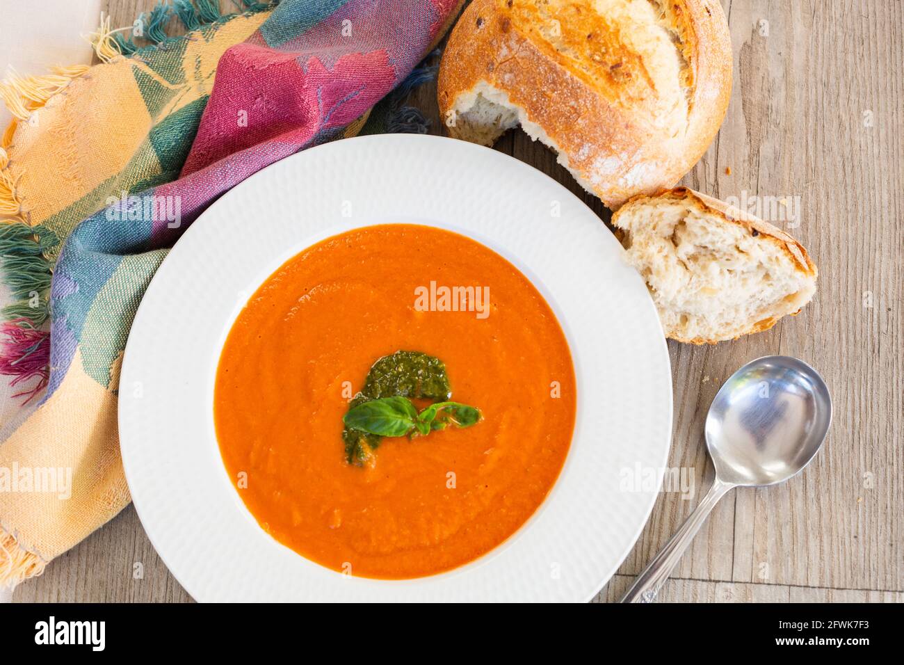 Pumpkin soup in white bowl with multigrain bun Stock Photo