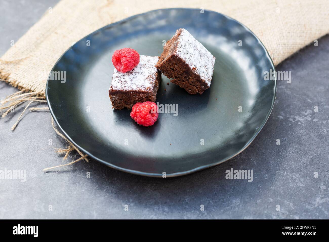 Two brownie slices on plate with raspberries Stock Photo